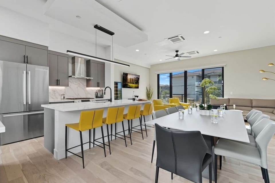 Fully equipped kitchen with stainless steel appliances, a sleek kitchen island with a breakfast bar for casual seating for 4, plus a large dining table for 8. (2nd Floor)
