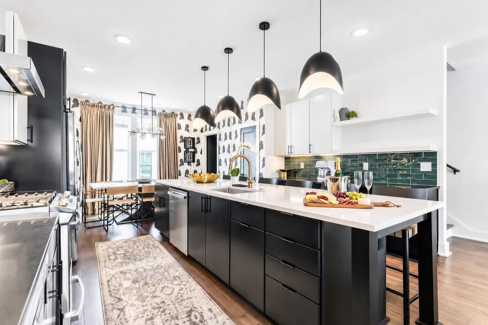 The kitchen island is where the group gathers: pendant lights overhead, bar seating around you, and the cook stays in the conversation instead of hidden away