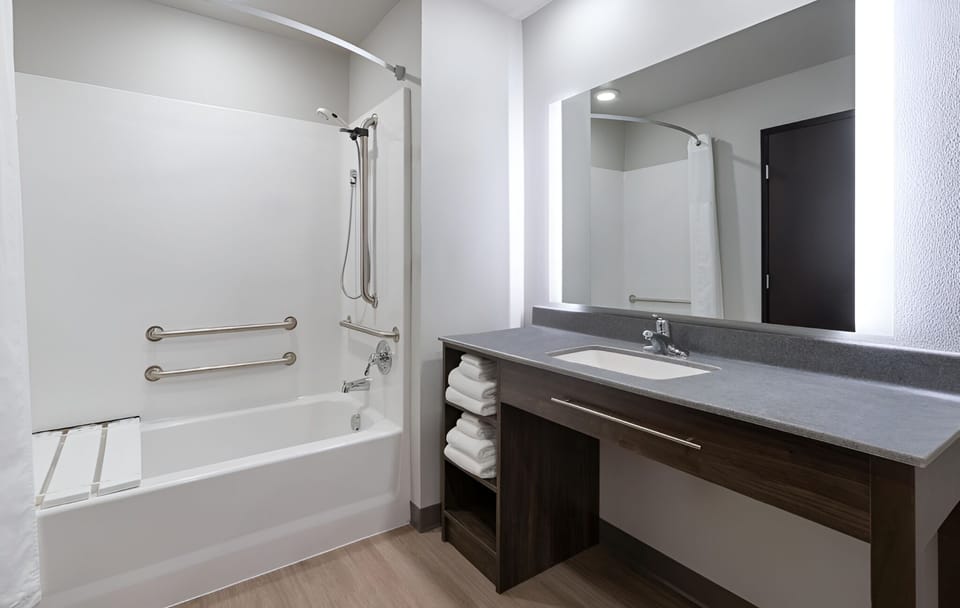 Refresh in a spotless bath with bright vanity lighting.