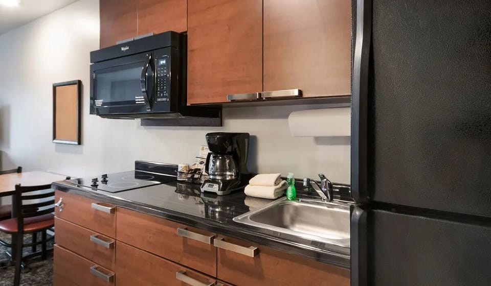 Cook and snack easily with fridge, microwave, and sleek counters.