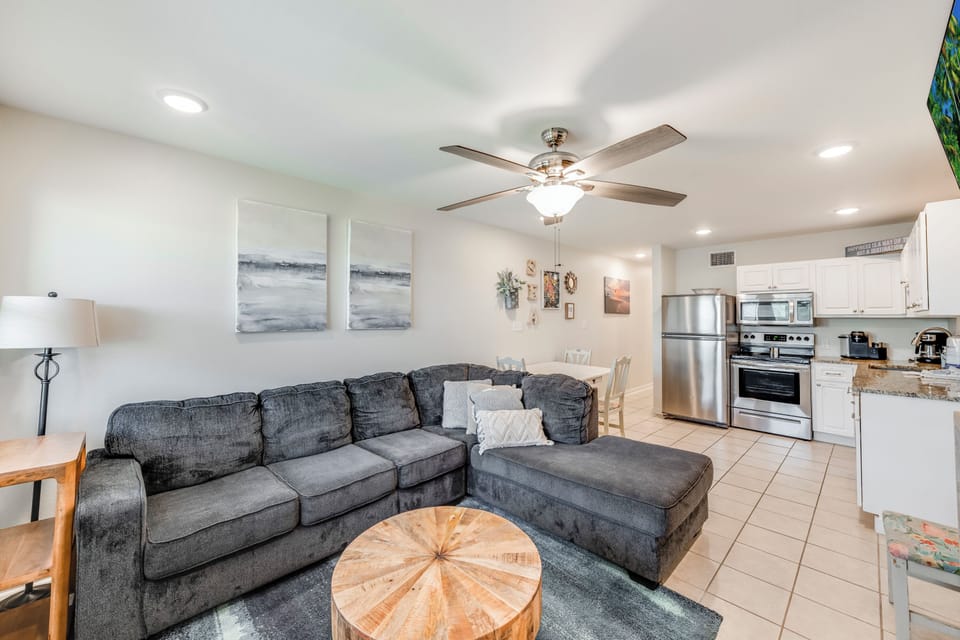 Unwind in your open-concept living space where coastal artwork meets modern comfort, complete with a full kitchen for home-cooked meals.