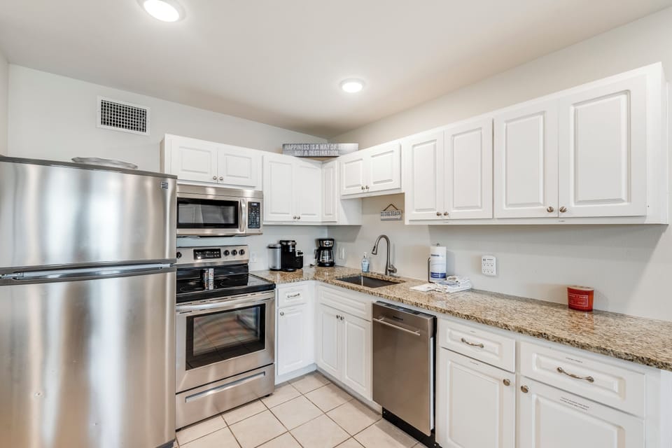 Your fully-equipped kitchen features stainless steel appliances, granite countertops, and crisp white cabinetry perfect for preparing home-cooked meals.