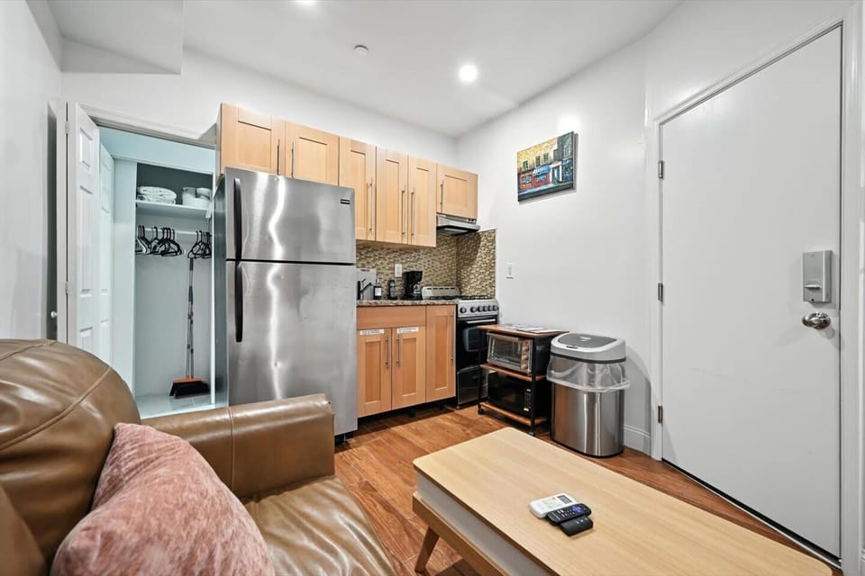 Dine in with ease using the fully functional kitchenette. This image shows the cooking area, complete with a stove, microwave, and coffee maker, allowing you to enjoy meals and beverages without leaving your apartment.