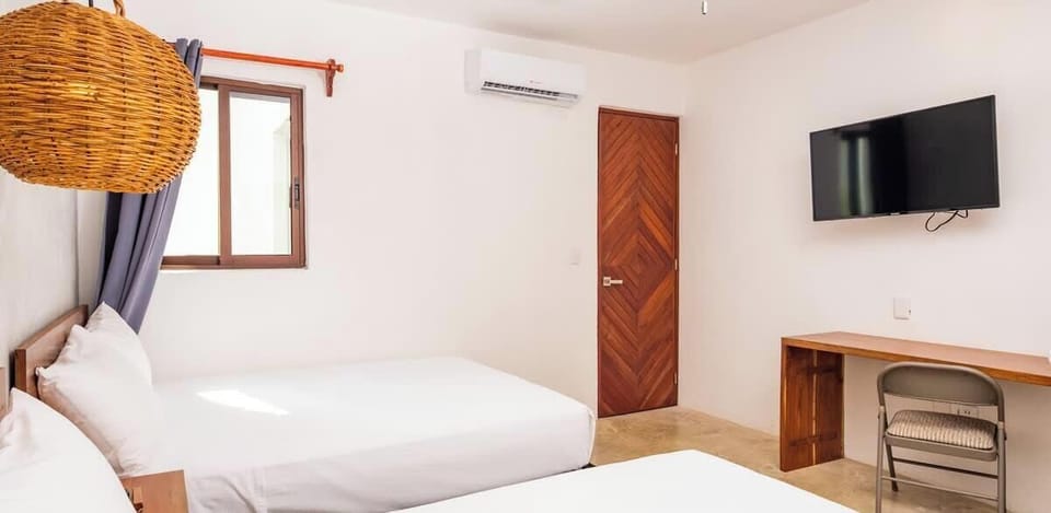 Cómoda habitación con dos camas individuales, TV plana y escritorio