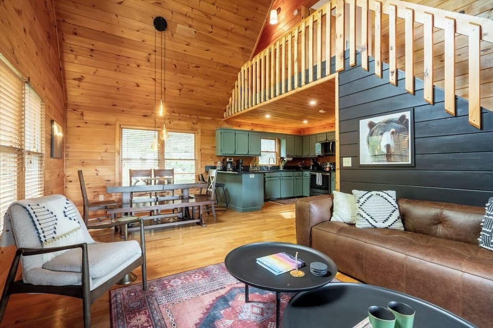A warm and inviting cabin living space featuring modern rustic design, an open kitchen, and plenty of room to gather and relax with family and friends.