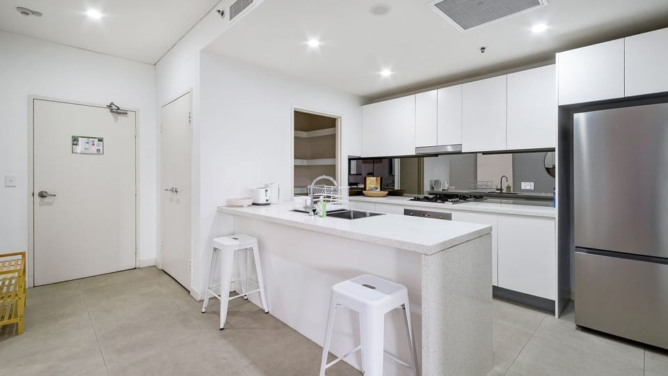 Fully equipped kitchen with island bench and seating.
