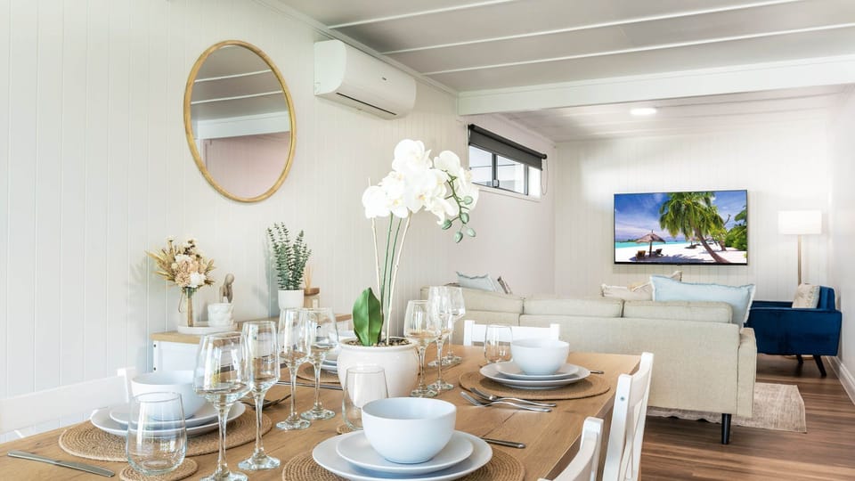 Stylish dining area with set table, wall mirror, and elegant decor