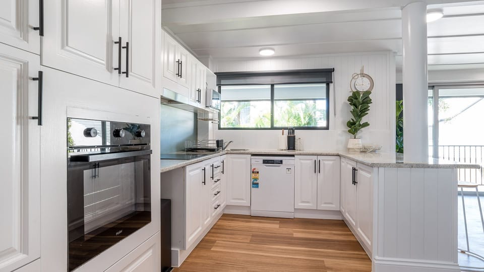 Contemporary kitchen with oven, dishwasher, and sleek cabinetry