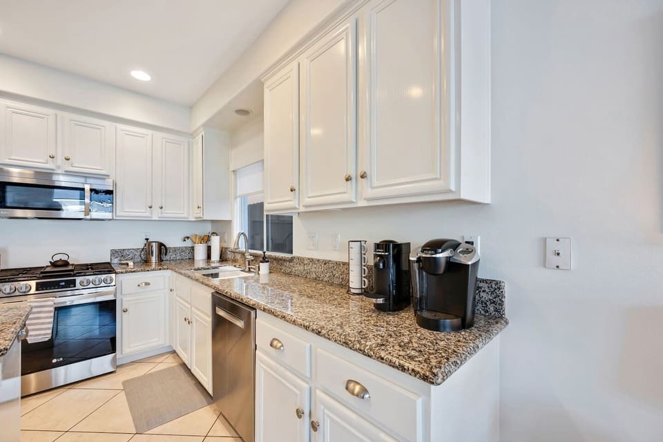 Kitchen with stainless appliances, Keurig and Nespresso coffee makers.