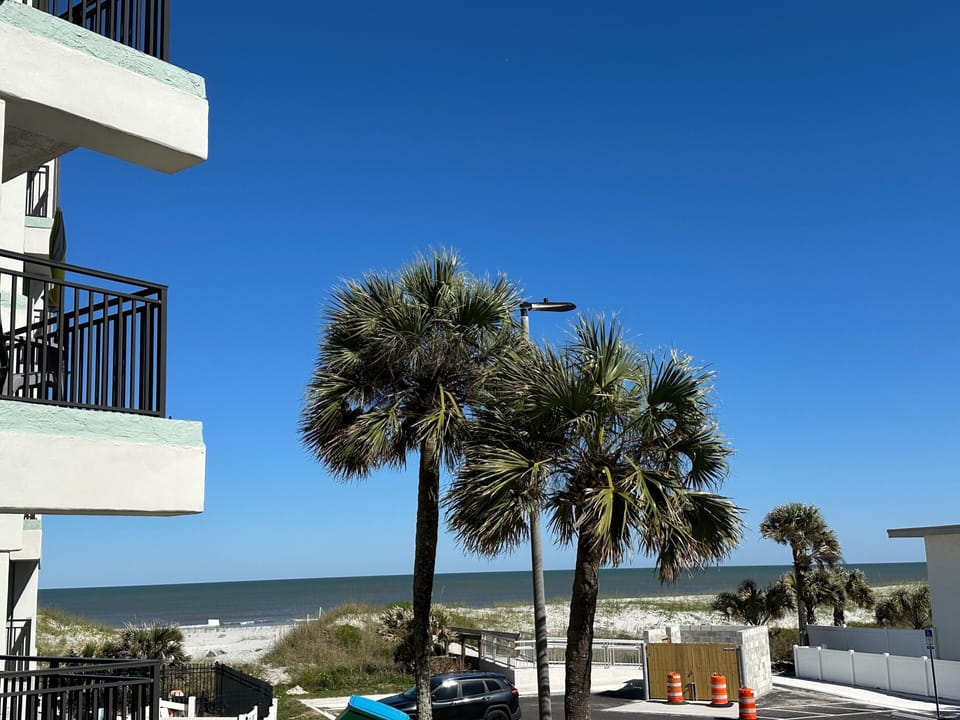 Ocean view with swaying palm trees and direct beach access just steps away—perfect coastal setting.