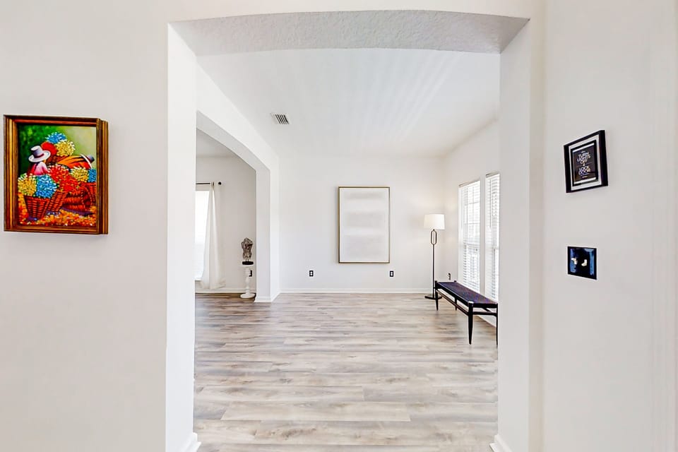 Thoughtfully detailed with a sleek accent bench, minimalist lighting, and framed artwork.