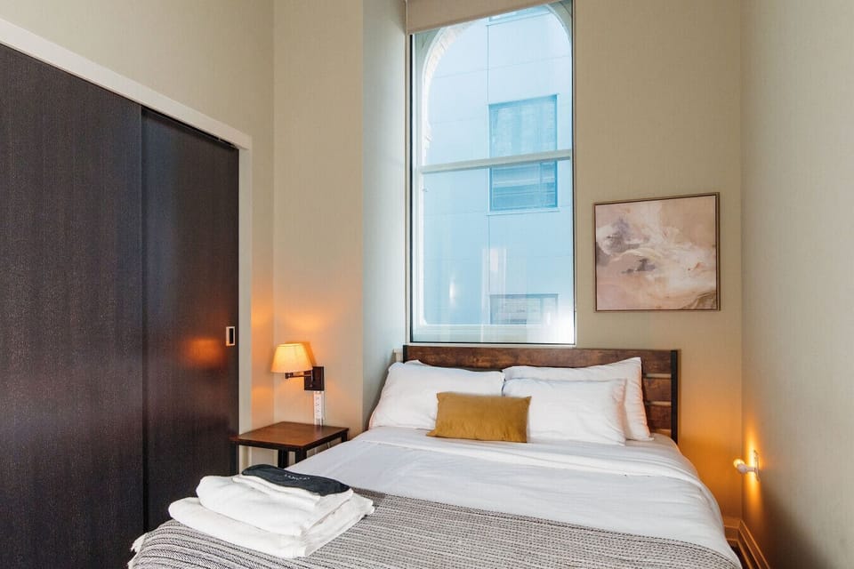 The master bedroom features an en-suite bathroom, original arched window, and an adjustable standing desk