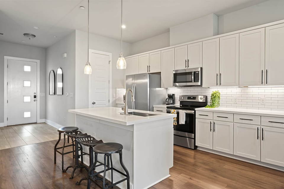 Fully stocked kitchen with quartz counters & stainless appliances.