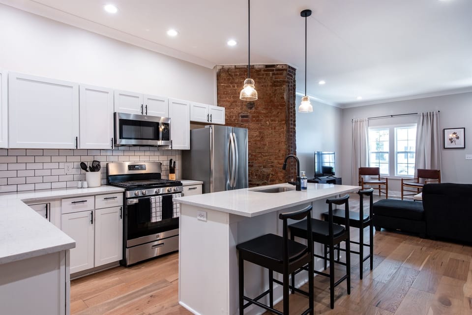 Cook up a feast using the premium stainless steel gas range set against crisp white subway tile. The open shelving and natural brick accents make this culinary space incredibly inviting.
