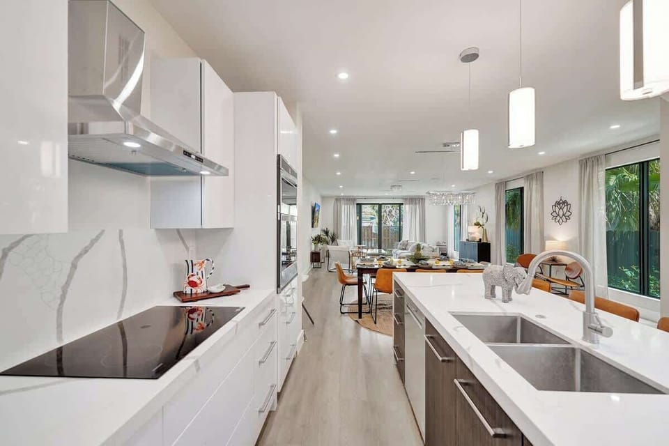 Modern chef’s kitchen flowing seamlessly into dining, lounge, and garden spaces.