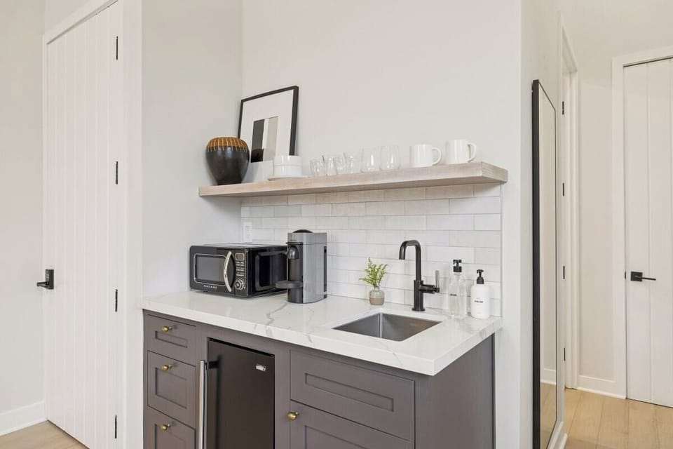 Kitchenette with mini-fridge, sink, and a Nespresso (no stove)