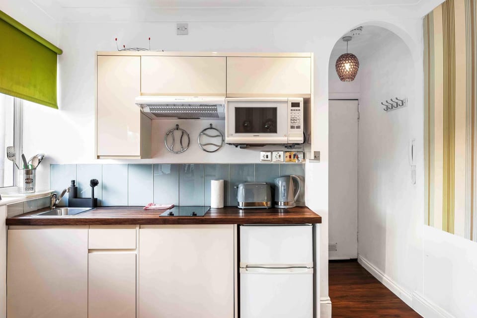 Modern kitchenette with microwave, fridge, and coffee/tea essentials for simple meals