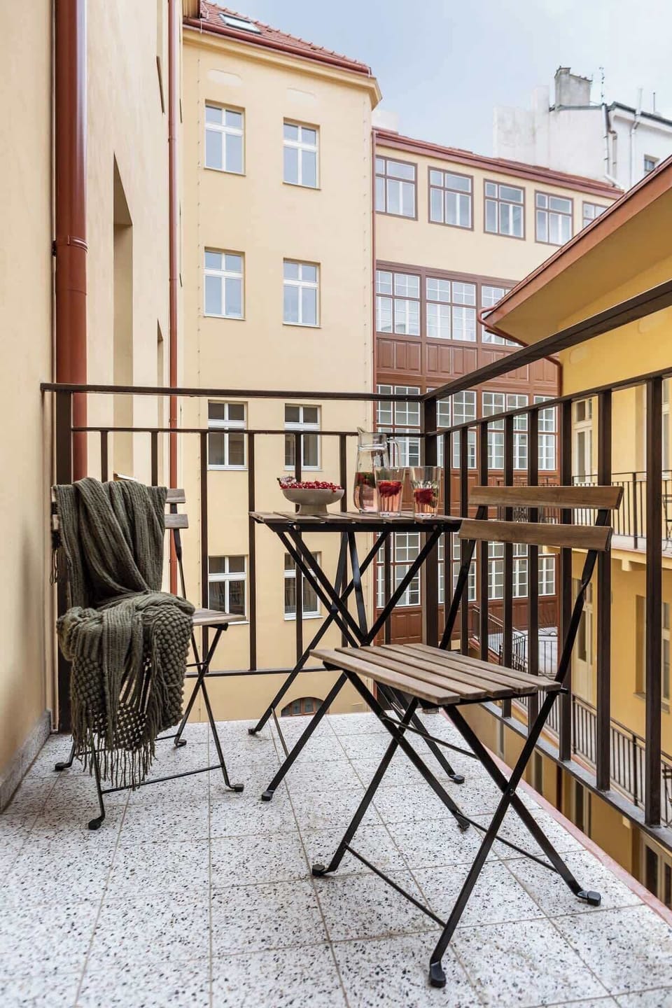 Traditional gallery-style balcony (pavlač), a shared space typical for historic Prague houses. Guests can enjoy a shared balcony in gallery style, offering outdoor seating right by the apartment.