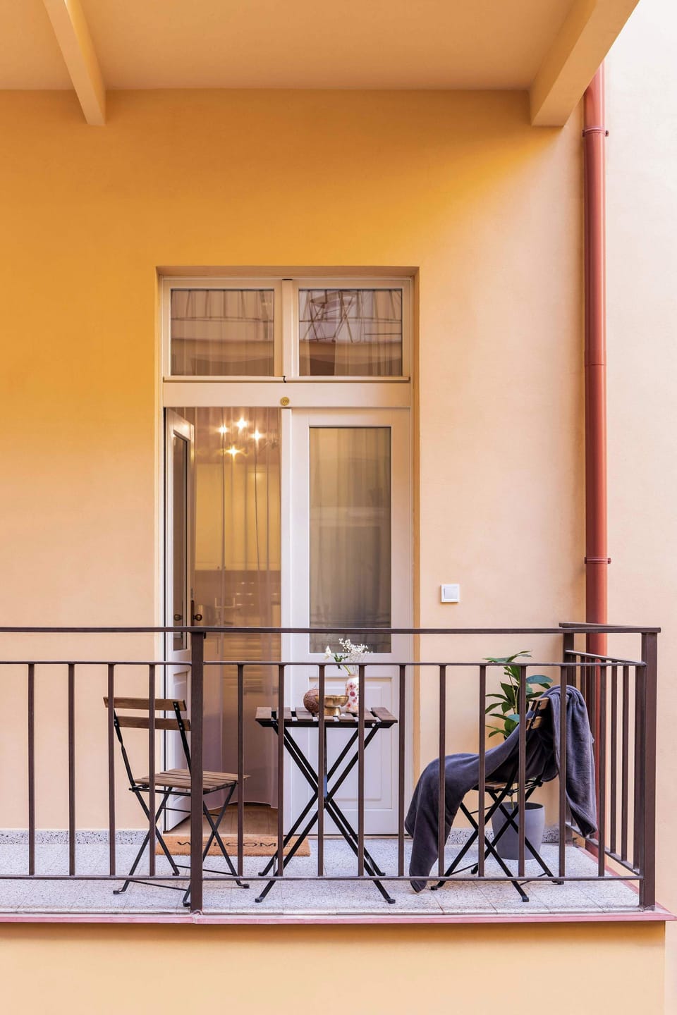 Traditional gallery-style balcony (pavlač), a shared space typical for historic Prague houses. Guests can enjoy a shared balcony in gallery style, offering outdoor seating right by the apartment.