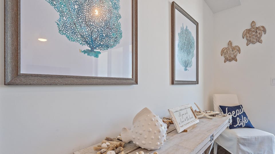 This beautifully decorated coastal space, featuring charming nautical accents and a functional fold-out table, is a bright, inviting area to dine.