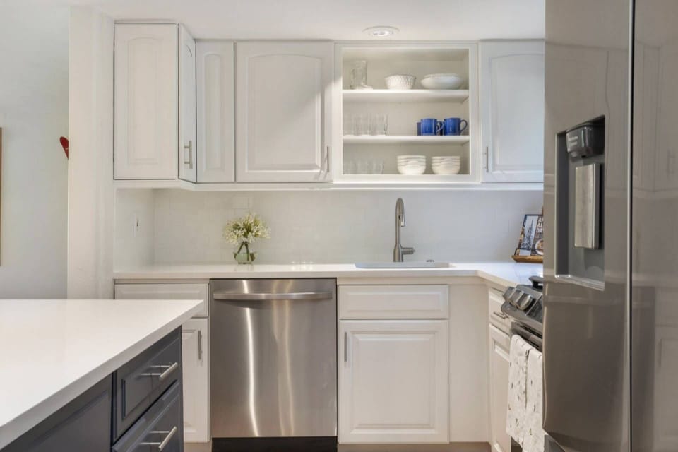Bright and beautiful! The kitchen shines with white cabinets and sleek stainless steel appliances.
