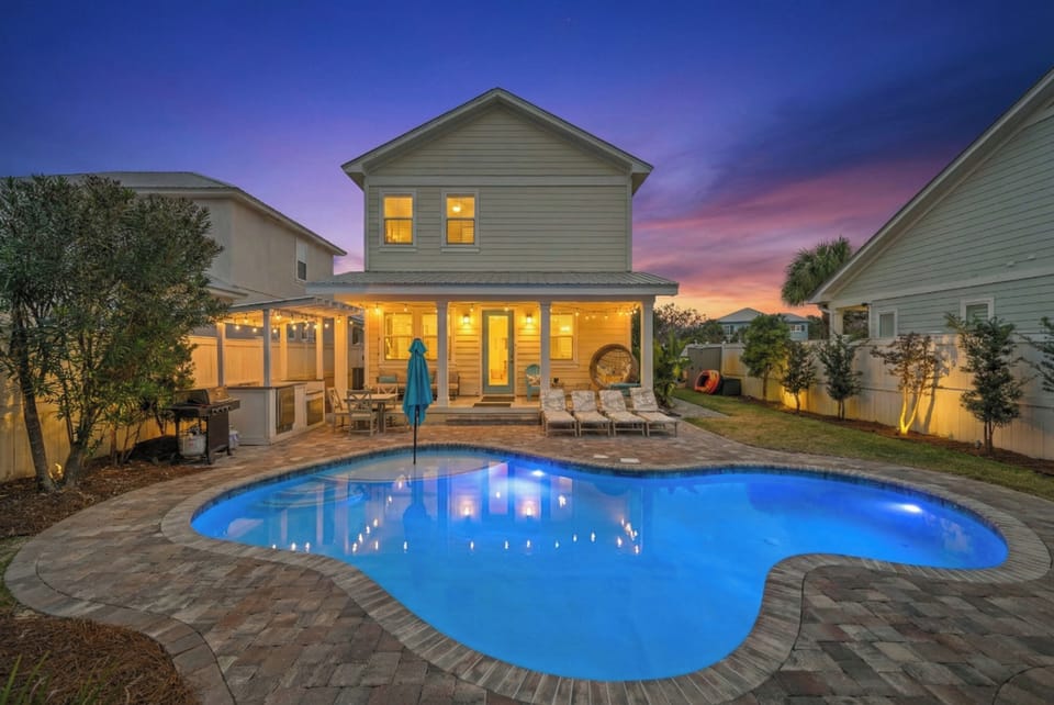 Twilight view of the heated private pool and spacious patio area.