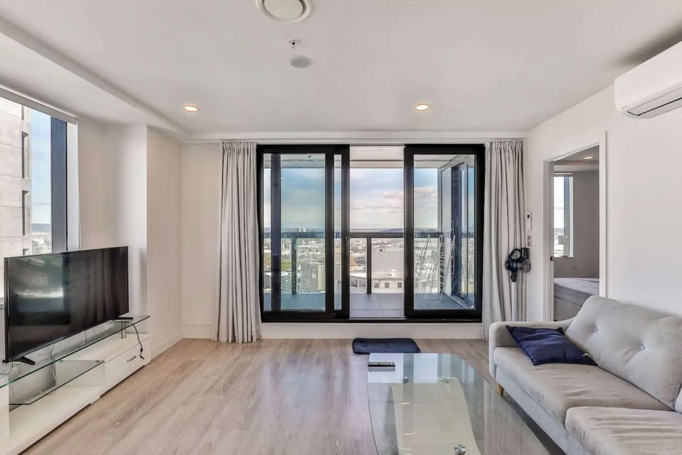 Spacious living room, TV, sofa, balcony.