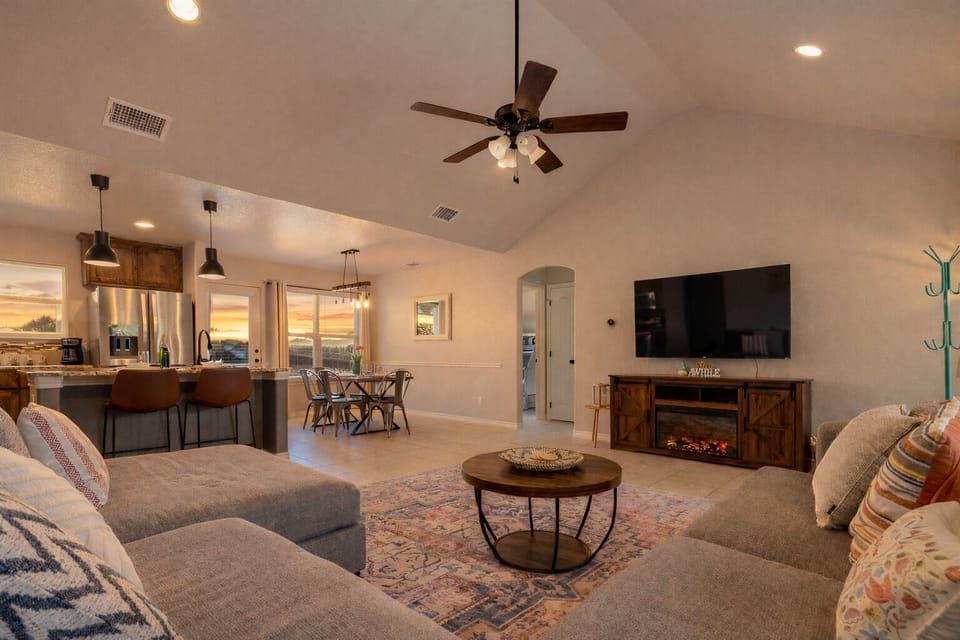 Spacious living room w/ vaulted ceilings, comfy sectional & electric fireplace.