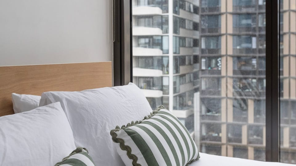 Comfortable bed with striped pillows and natural light