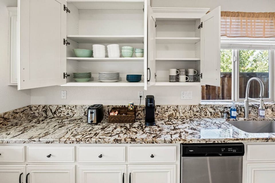 Find dishes, mugs, and essentials easily in this well-stocked kitchen.
