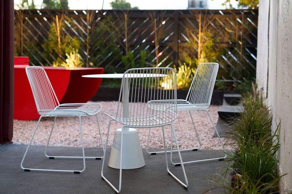 Unwind with a glass of wine or your favorite book in this peaceful, stylishly lit backyard patio nook.