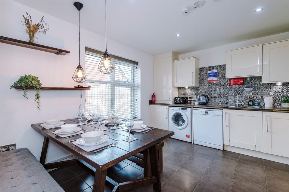 The bright and spacious kitchen benefits from a large dining table and cushioned benches