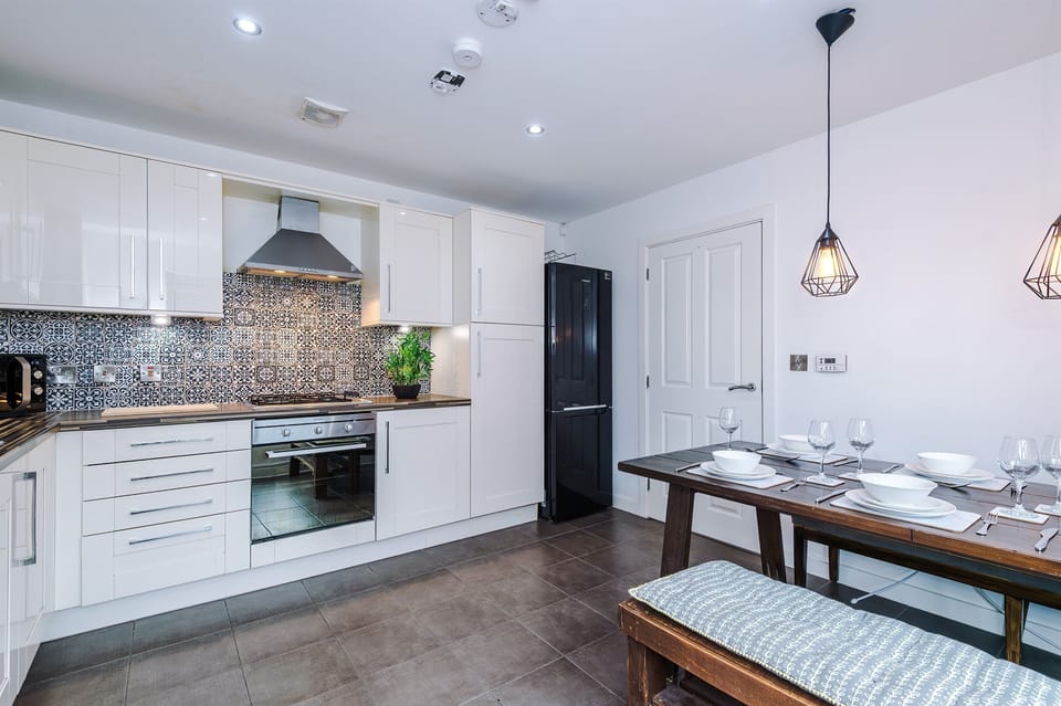 The bright and spacious kitchen benefits from a large dining table and cushioned benches