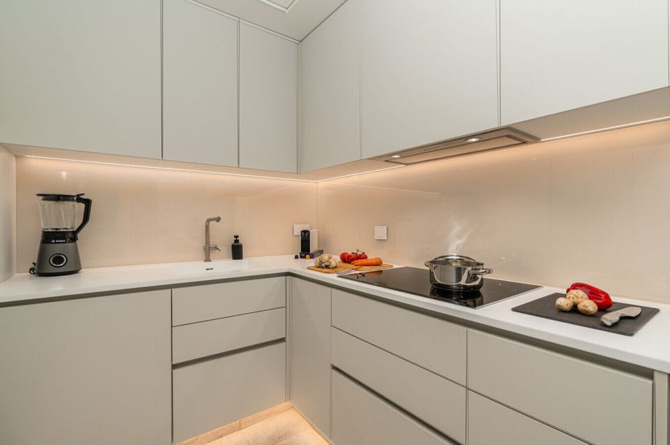 Fully equipped kitchen with bright surfaces and subtle lighting.