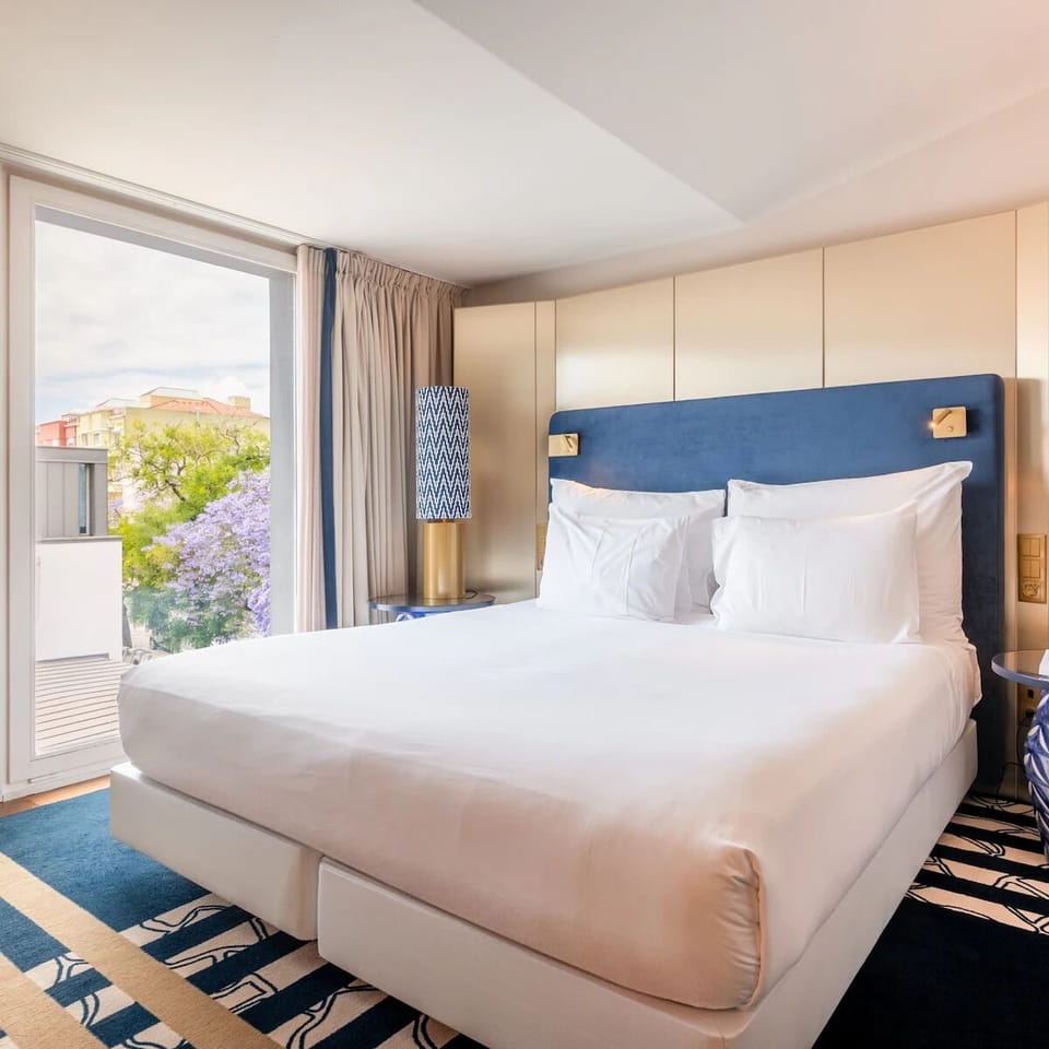 Drift off in a cloud-soft bed beside leafy views.