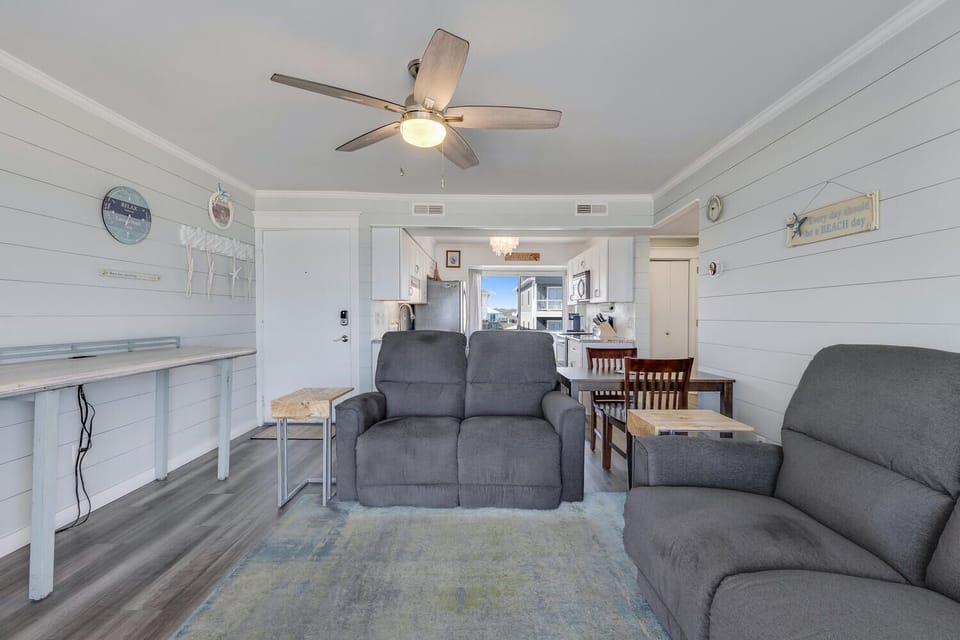 Relax in your cozy living space with comfortable recliners and coastal charm, perfect for unwinding after beach days.