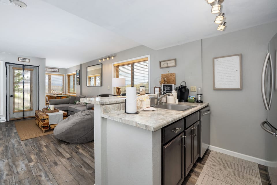 Your open-concept space features marble countertops and stainless appliances, flowing seamlessly into a cozy living area perfect for relaxing.