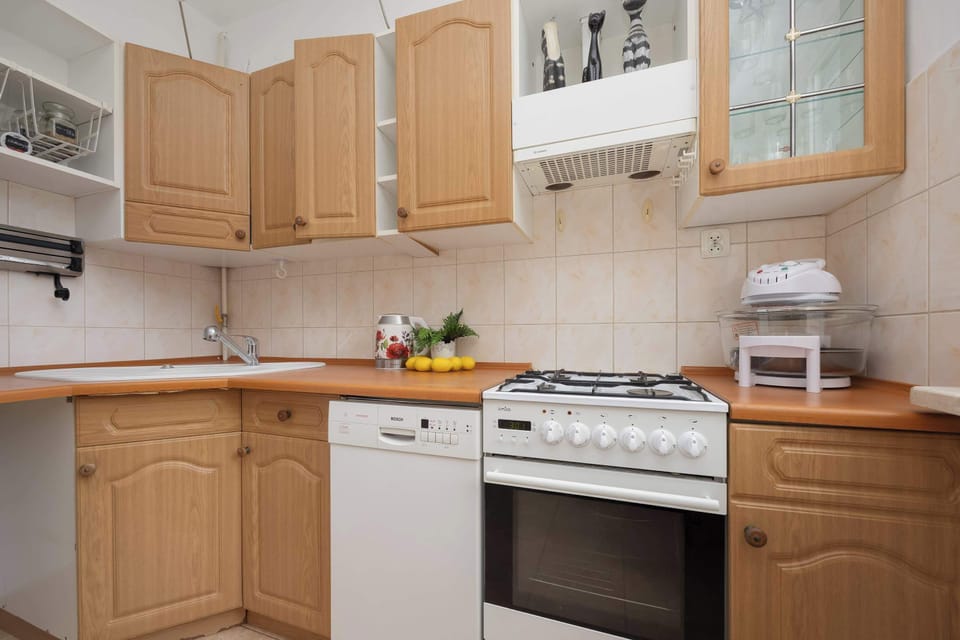 The functional kitchen with wooden cabinets and full equipment allows you to prepare home-cooked meals with ease.