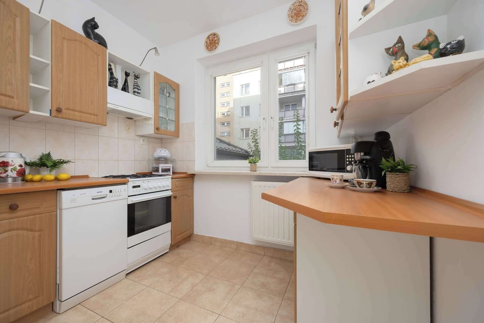 The bright kitchen with a wide countertop and a window overlooking the city invites shared cooking and time spent over meals.