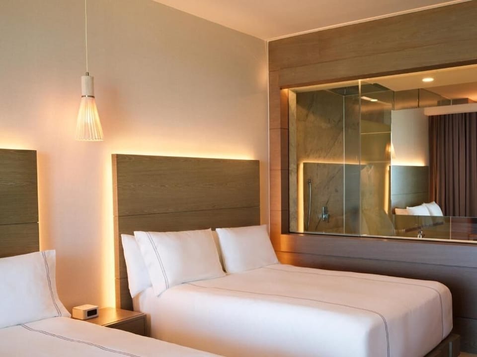 Relax in a serene bedroom with sleek glass-accent styling.