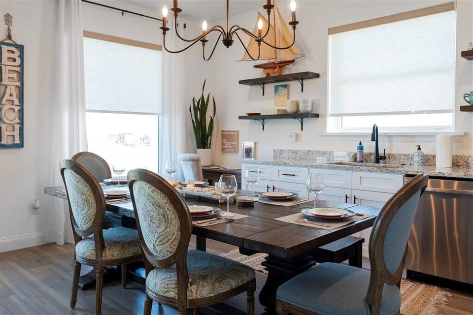Bright dining area with a set table and a sailboat decoration.