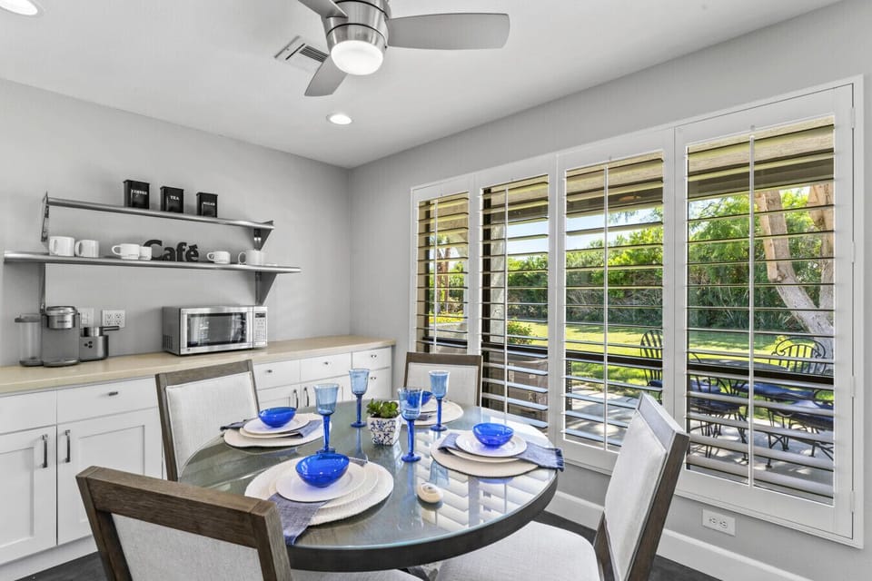 Dining area set for meals w/ easy flow into the kitchen & patio views through glass doors