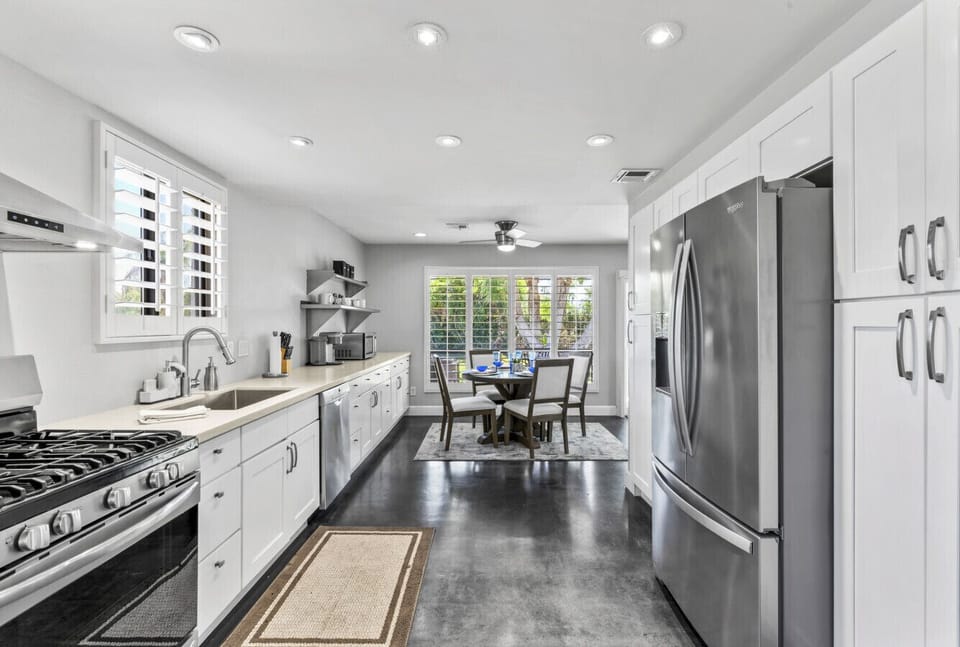 Spacious, modern kitchen with stainless steel appliances, granite countertops, and dining for six.