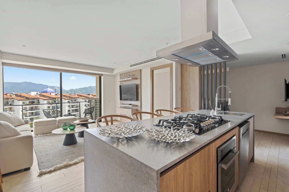 Fully equipped kitchen with refrigerator and induction cooktop. It has a laundry area and pantry.