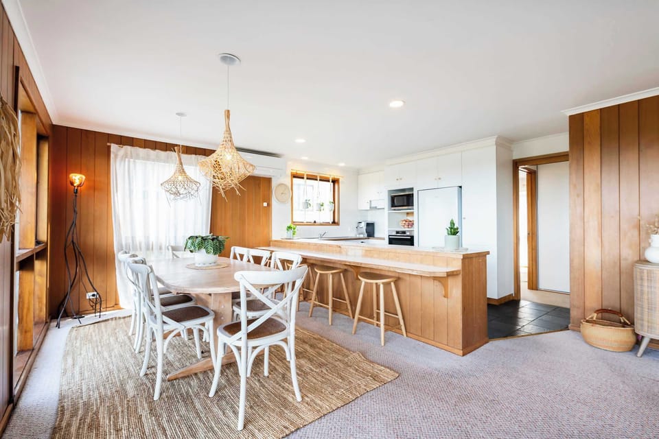 An open-concept dining area seamlessly connected to the kitchen, bathed in sunlight and offering beautiful views through the windows