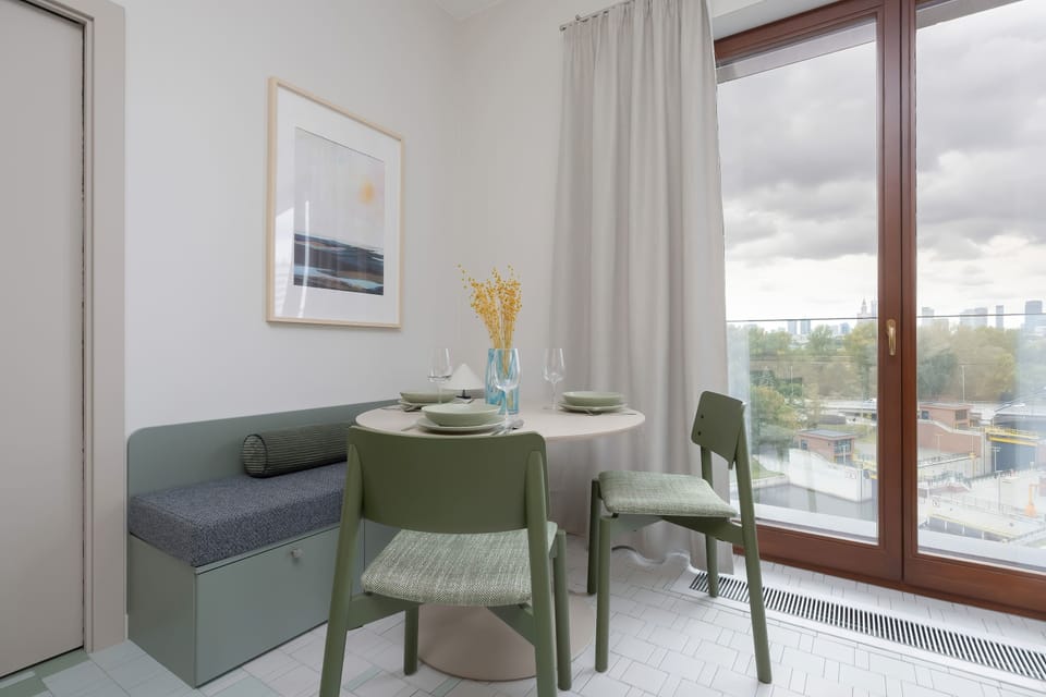 The intimate dining corner by the window lets you enjoy a meal with a city view and plenty of natural daylight.