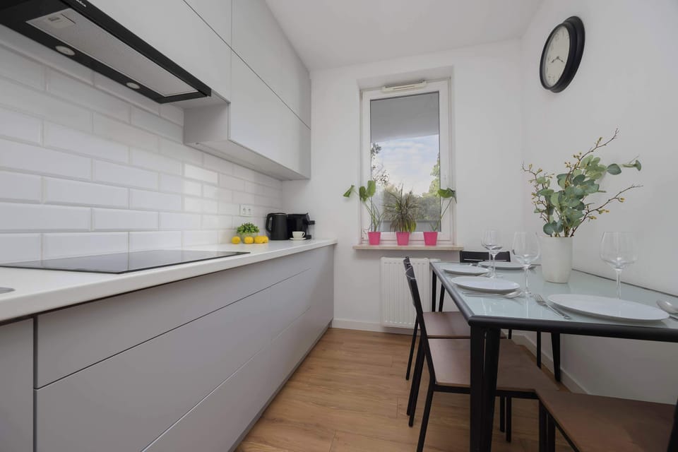 The kitchen with a long countertop and white cabinetry offers functionality and comfort for meal preparation.