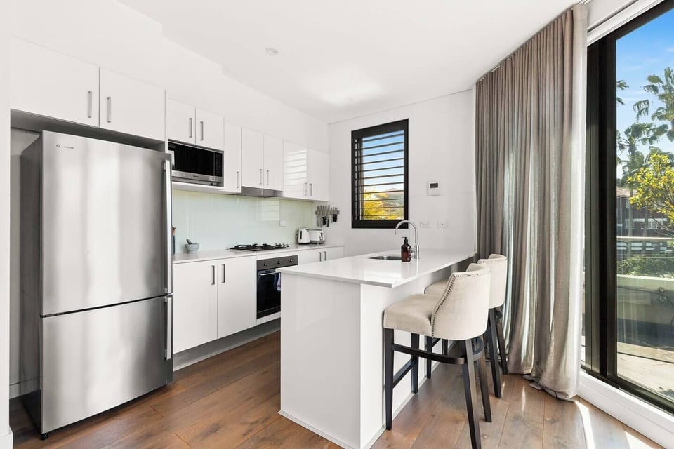 Start your day with coffee at the breakfast bar or unwind in the evening with wine, all set beside expansive windows that frame leafy views.