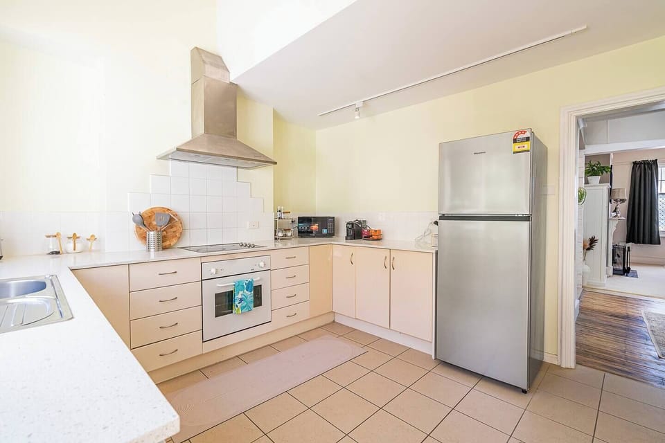 The kitchen includes all the essentials for home cooking—oven, stovetop, microwave, fridge, dishwasher, toaster, and a full range of cookware.