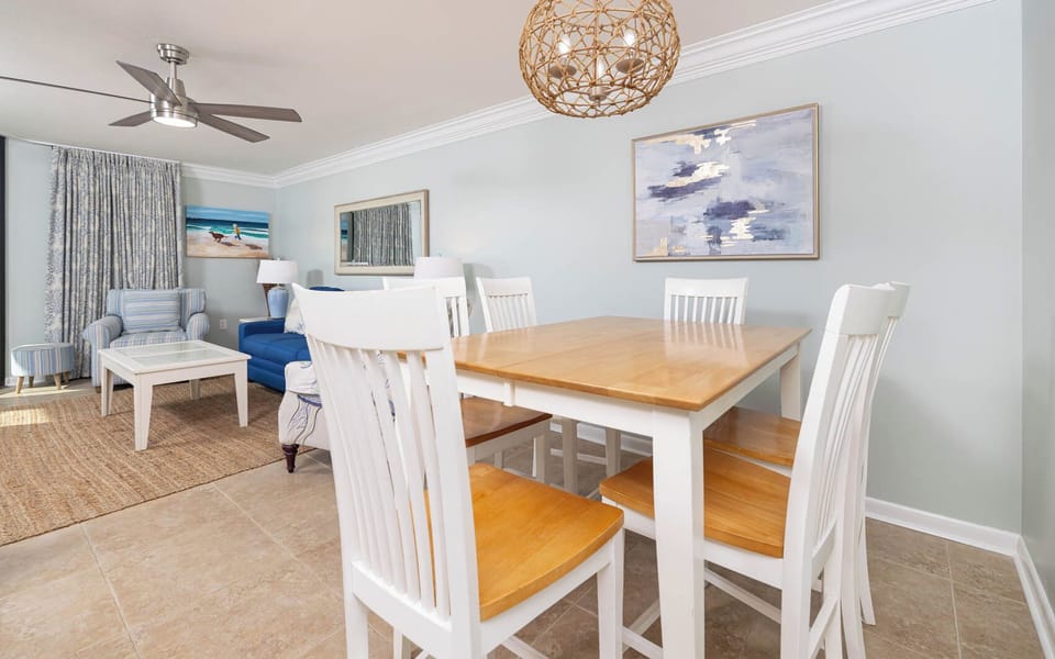Gather around the dining table with friends, surrounded by coastal decor and inviting seating in this airy space